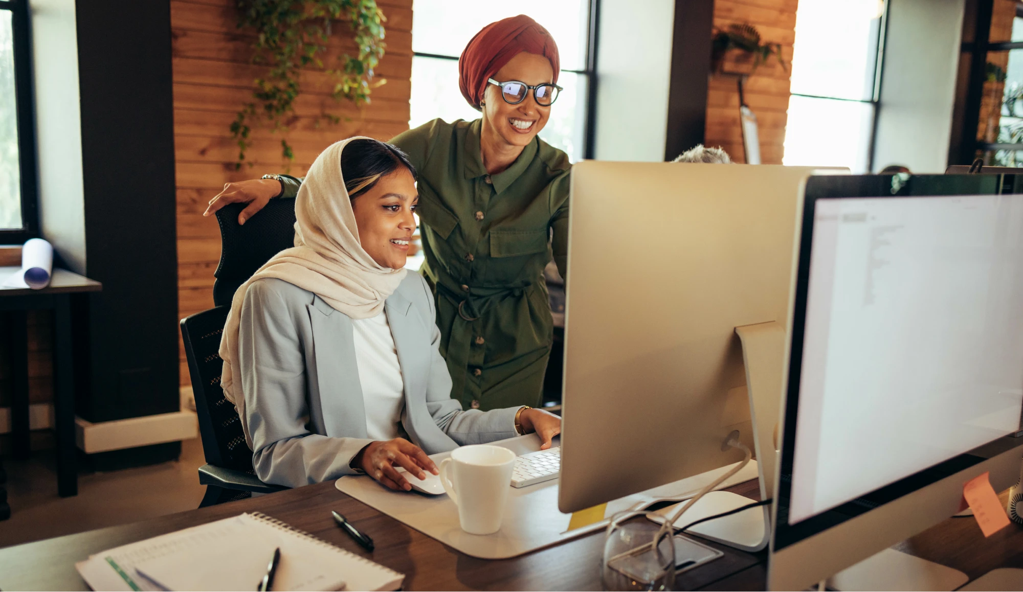 Two muslim women collaborating at desk